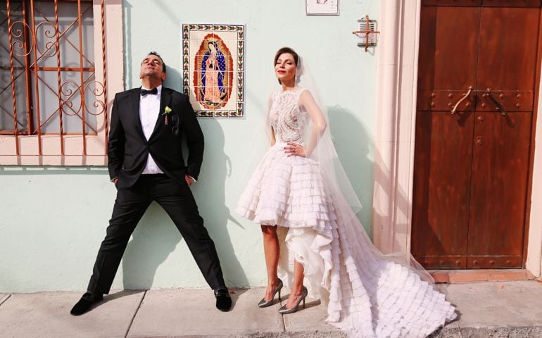 A bride and groom basking in the sun out on the street