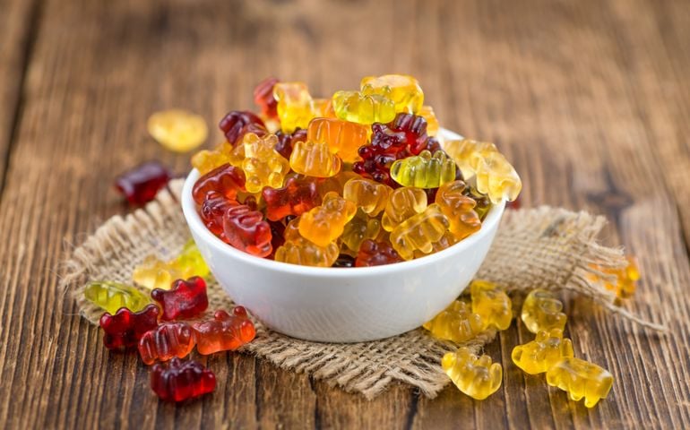 Bowl with Gummy Candy (selective focus) on wooden background