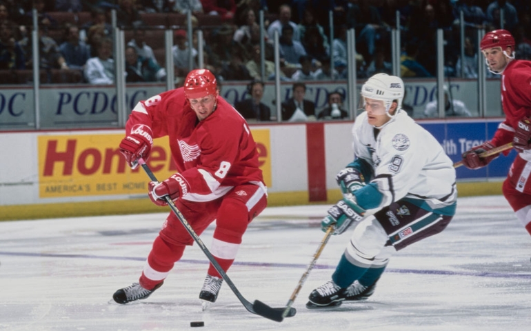 Igor Larionov #8, Center for the Detroit Red Wings and #9 Paul Kariya, Captain and Left Wing for the Mighty Ducks of Anaheim challenge for the puck during their NHL Western Conference, Pacific Division game on 24th November 1996 at the Arrowhead Pond of Anaheim arena in Anaheim, California, United States. The Mighty Ducks won the game 3 - 1.