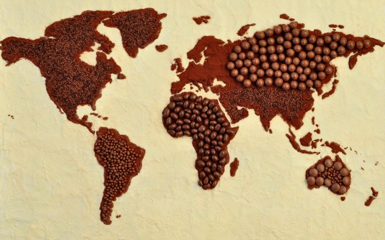 Chocolate world map. White chocolate oceans, milk chocolate cocoa dusted continents with various milk and dark chocolate toppings.