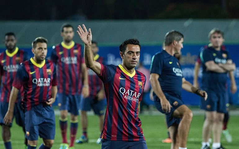 HEBRON, WEST BANK - AUGUST 03: Xavi Hernandez of FC Barcelona waves to the crowd at the Dura Stadium on August 3, 2013 in Hebron, West Bank. Members of the FC Barcelona squad have travelled to the Middle East to visit Israel and the West Bank as part of a two-day 'peace tour'.