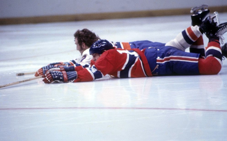 UNIONDALE, NY - 1972: Rejean Houle #14 of the Montreal Canadiens and Gerry Hart #2 of the New York Islanders fall to the ice during an NHL game circa 1972 at the Nassau Coliseum in Uniondale, New York.