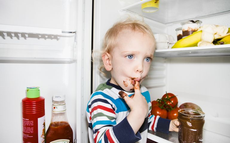 Toddler sucking chocolate off finger