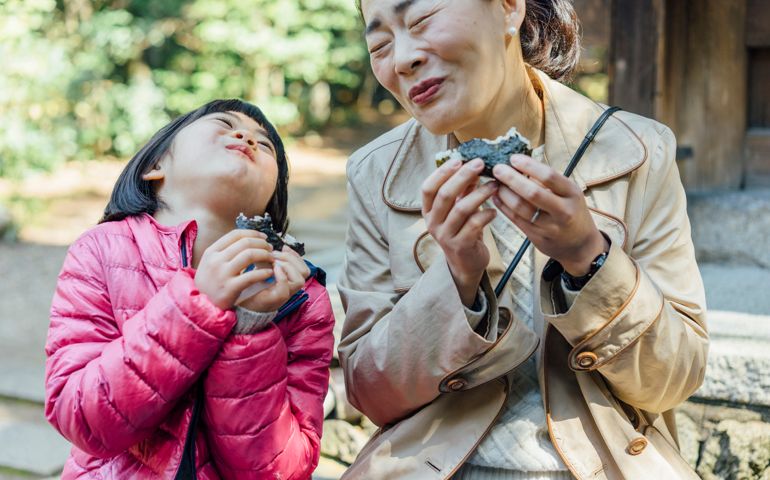 Japanese mother and daughter eating onigiri together