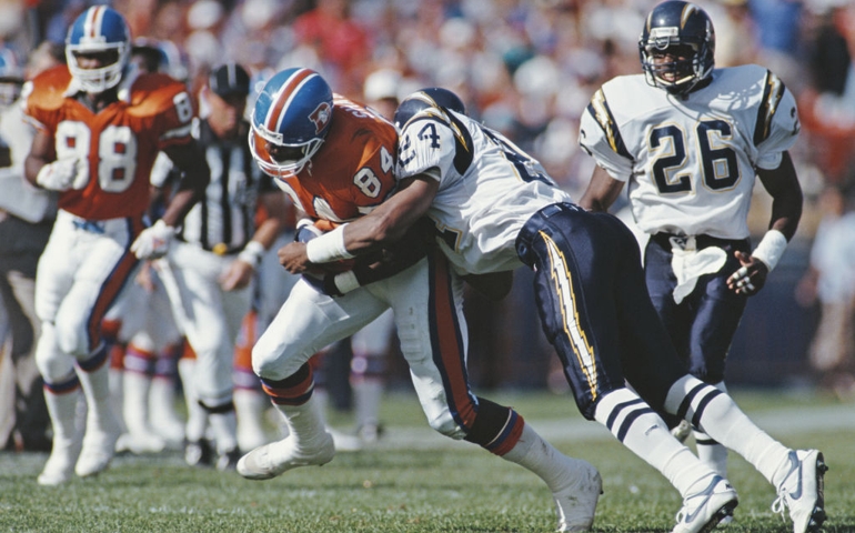 Shannon Sharpe #84, Tight End for the Denver Broncos is tackled by Stanley Richard #24 Defensive Back for the San Diego Chargers during the American Football Conference West game on 13 September 1992 at the Mile High Stadium, Denver, Colorado,United States. The Broncos won the game 21 - 13.
