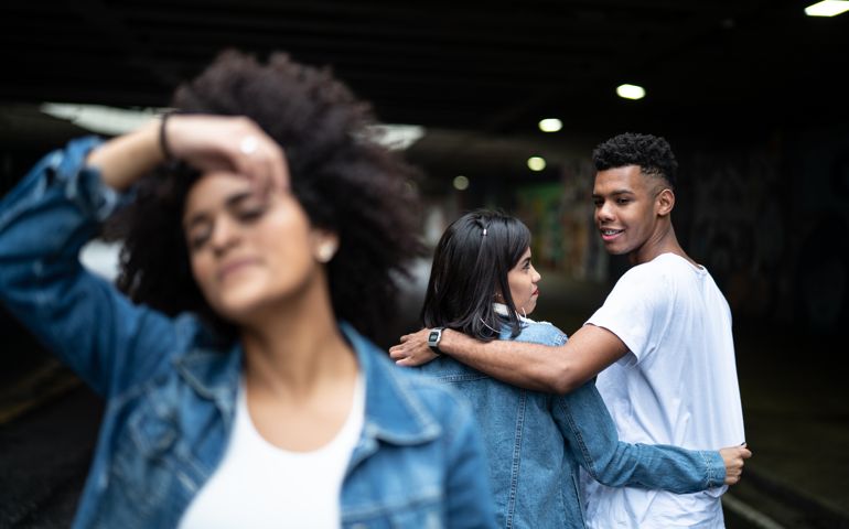 Disloyal man with his girlfriend looking at another girl