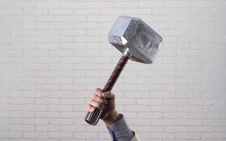 businessman's hand holds hammer Thor
