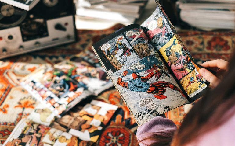 person reading comic book at home