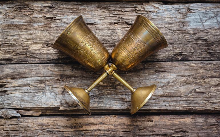 Golden goblets on the old wooden table background