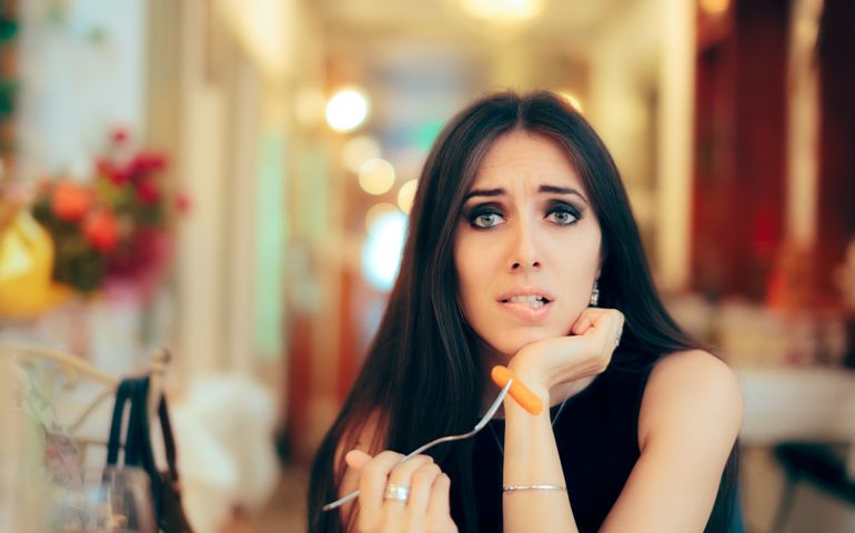 Funny Woman Eating Healthy Restaurant Food At a Party - Portrait of a girl trying a diet dish for a balanced lifestyle