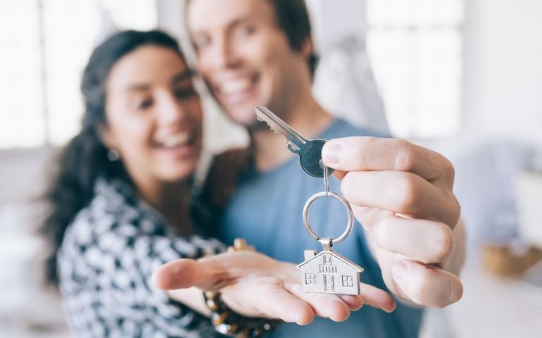 Couple cheerful home owners holding a key