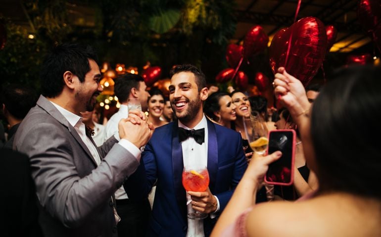 Groom and wedding guests laughing during party