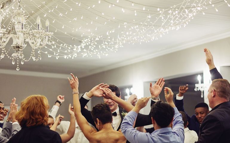 Shot of a young couple dancing with their friends at their wedding reception