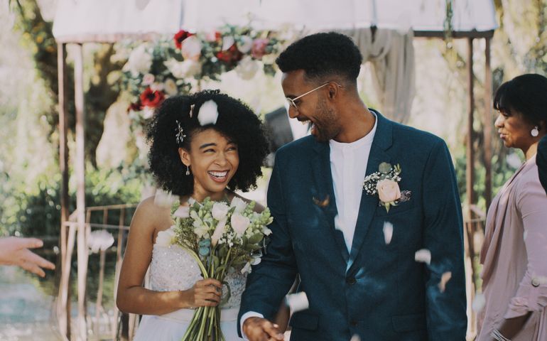 Cropped shot of a newlywed couple walking down the isle together after being announced as husband and wife