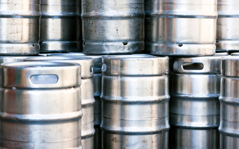 Closeup heap of shiny stainless steel beer kegs, full frame horizontal composition
