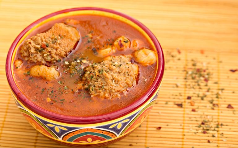 A high angle extreme close up shot of a festive bowl full of menudo, a traditional Mexican soup that is even eaten for breakfast because it is said it cures hangovers.