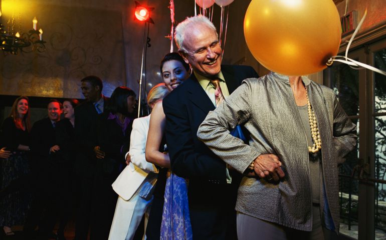 Mature couple leading conga line on dance floor