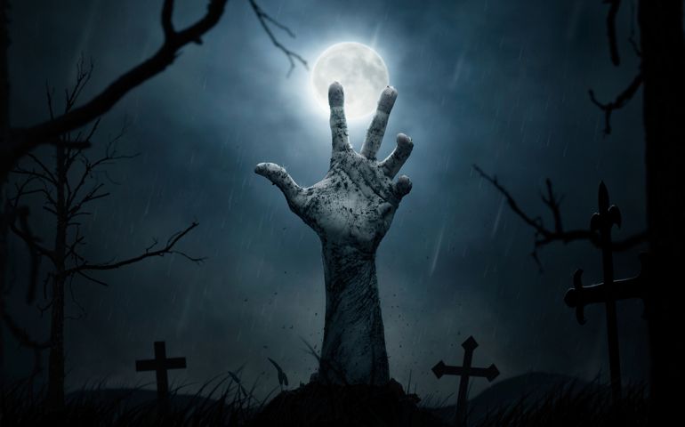 Halloween concept, dead man's hand coming out from the grave