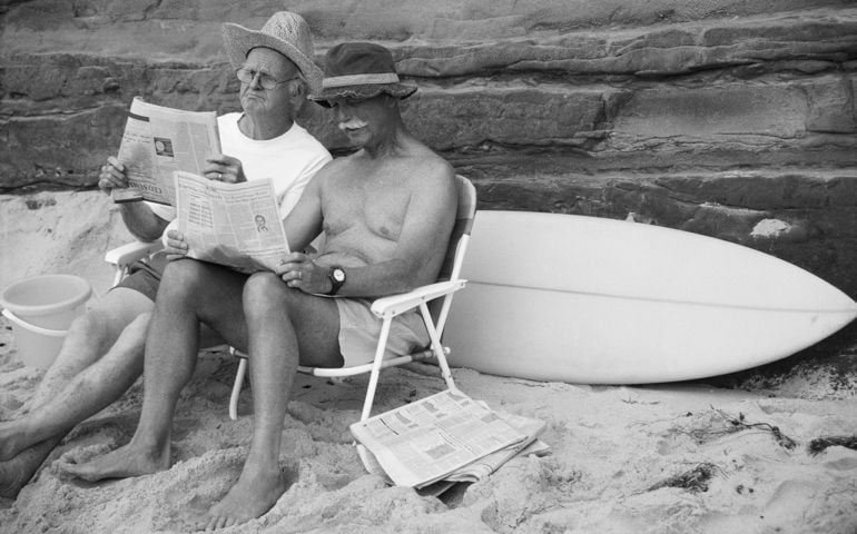 Elderly Men Reading Newspapers on Beach