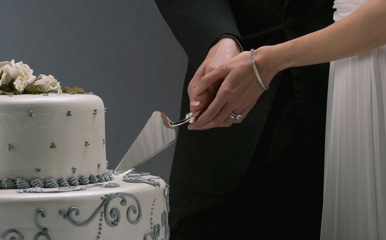 Bride and groom slicing elegant wedding cake