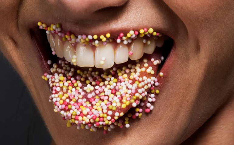 Female' tongue and lips covered in sugar sprinkles