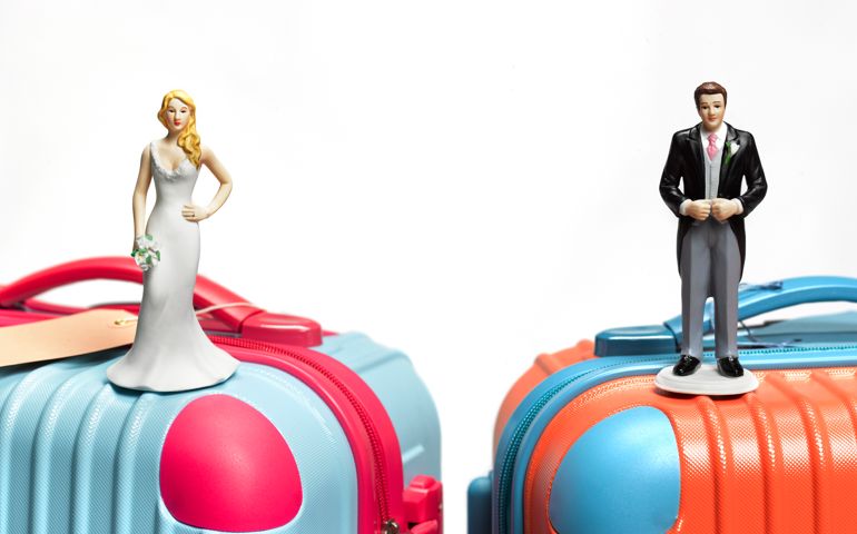 Bride and groom on suitcase