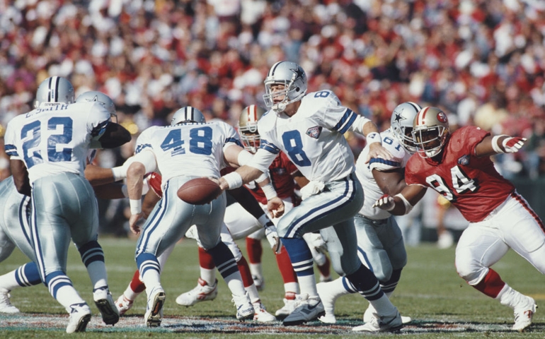 Troy Aikman #8, Quarterback for the Dallas Cowboys is hands off to running back Emmitt Smith #22 during the National Football Conference West game against the San Francisco 49ers on 13 November 1994 at Candlestick Park, San Francisco, California, United States. The 49ers won the game 21 - 14.