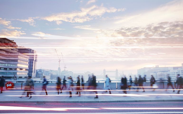 Business people walking through the city at dawn.