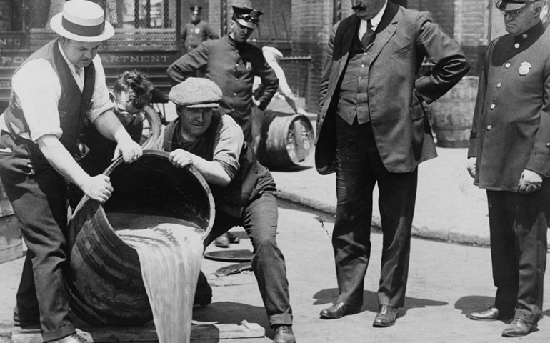 UNITED STATES - CIRCA 1921: New York City Deputy Police Commissioner John A. Leach, right, watching agents pour liquor into sewer following a raid during the height of prohibition