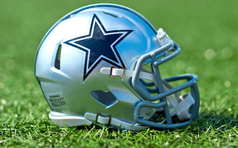 Dallas Cowboys replica helmet on artificial grass playing turf