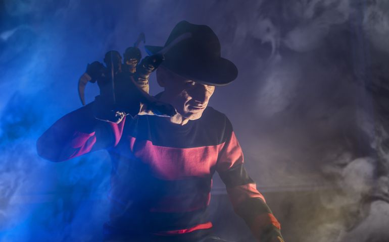 Cosplayer costume one man Freddy Krueger is a serial killer with a glove in the mist