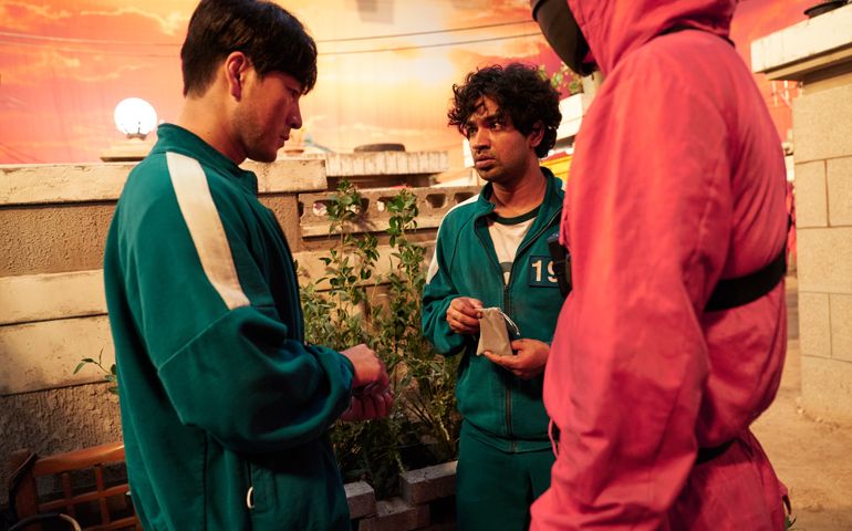 Ali Abdul, played by Tripathi Anupam, center , speaks with Sangwoo played by Park Hae-soo, in "Squid Game."
