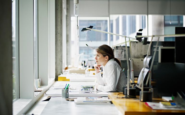 Architect sitting at desk looking out window