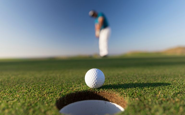 Golf ball entering the hole after successful stroke - Close up - Links Golf
