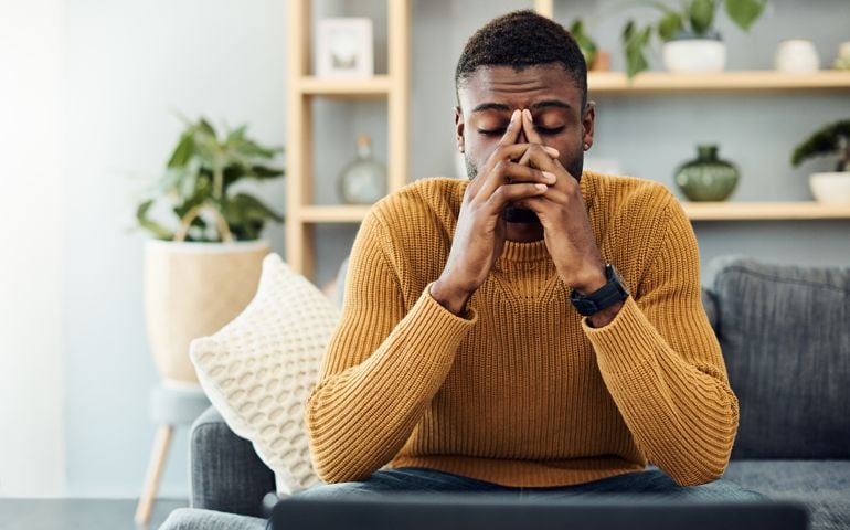 Shot of a young man looking stressed out at home