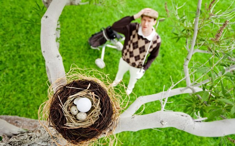 Photo of a golfer looking defeated as he realizes where his ball has landed.