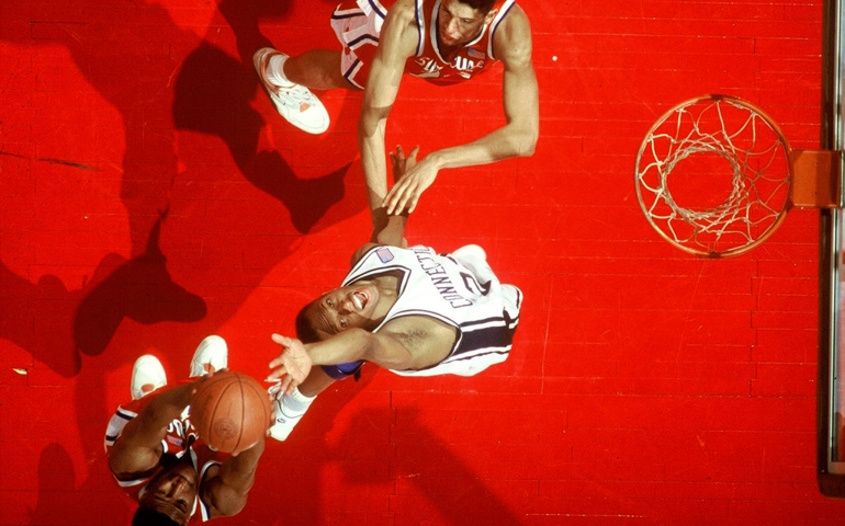 Aerial view showing the University of Connecticut's Rod Sellers reaching back as Syracuse foward Billy Owens rebounds the basketball, Hartford, CT, 1990.