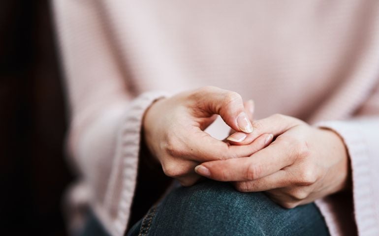 Cropped shot of a woman sitting on a sofa and feeling anxious