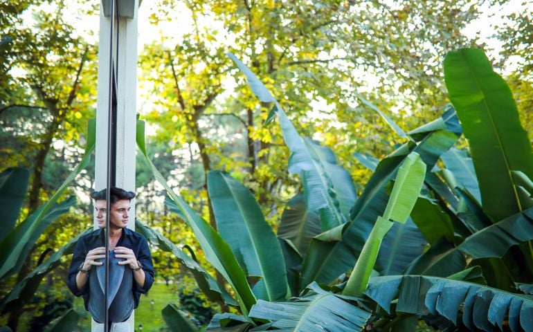 Young Man Sitting On The Windowsill And Looking At His Reflection, Finds Peace in Nature