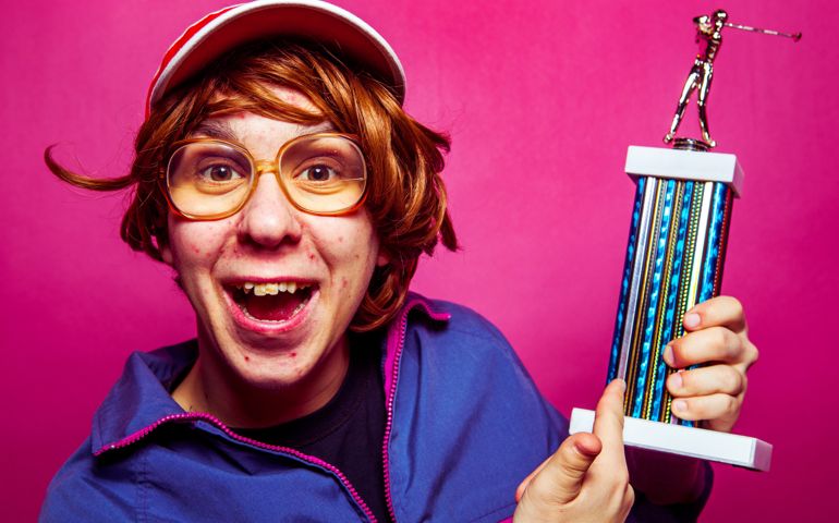 Nerdy sports guy holding a trophy.