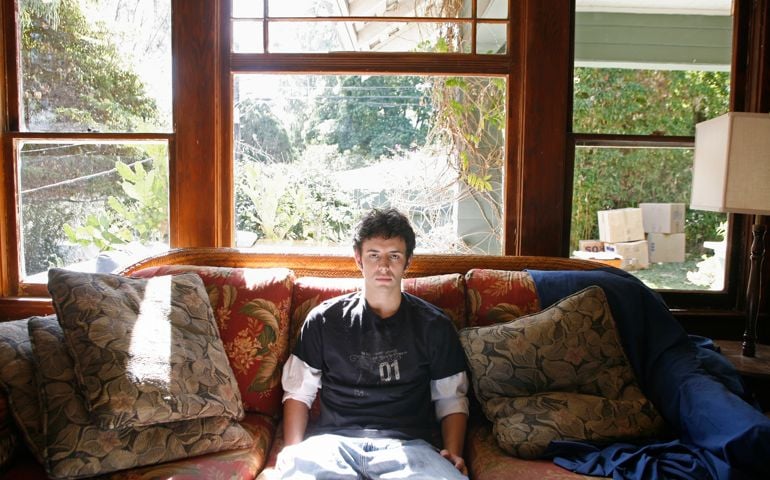Young man sitting in living room, portrait