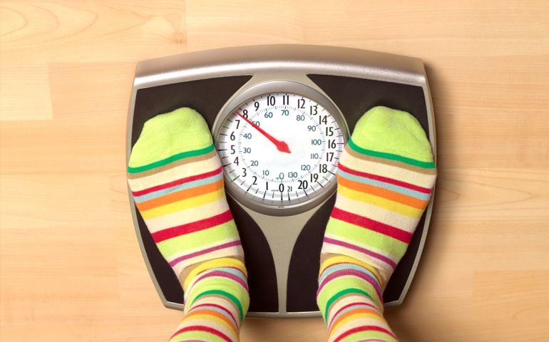 Dieting woman on bathroom scales