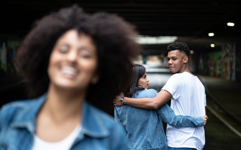 Disloyal man with his girlfriend looking at another girl