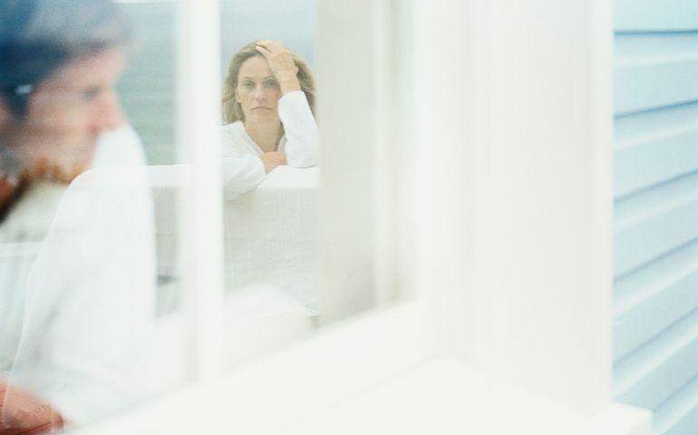 Couple sitting indoors, view through window