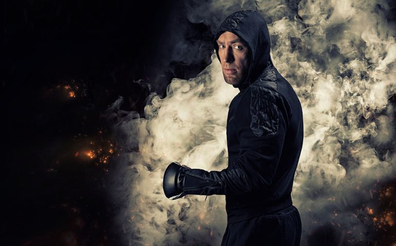 Mixed martial artist goes to battle in a sweatshirt amid fire and smoke