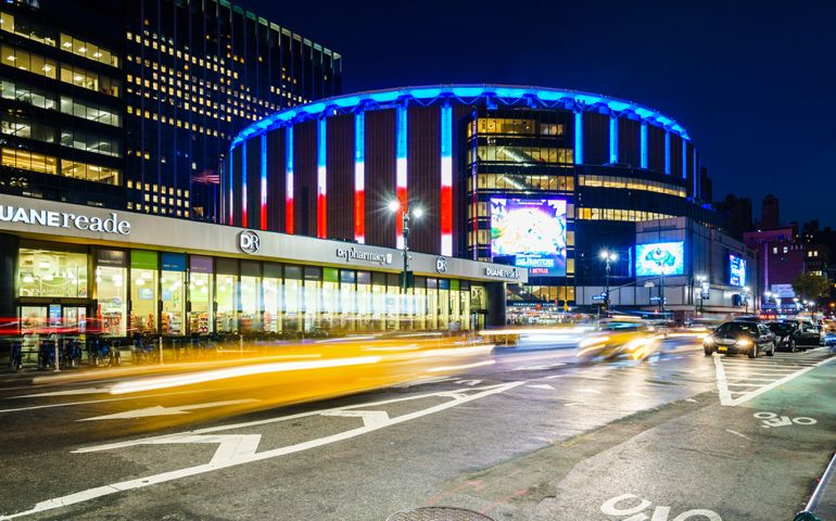 Madison Square Garden, New York, USA - 17 October, 2016: Illuminated stadium with car riding around.