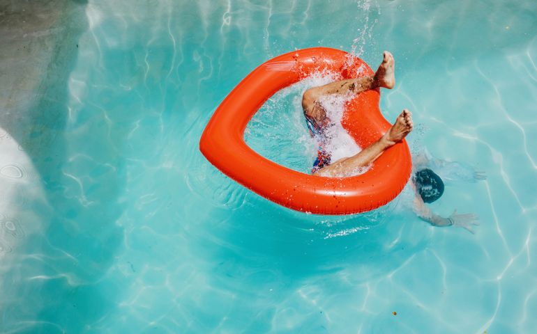 Man's feet protruding as he dives through heart-shaped inflatable