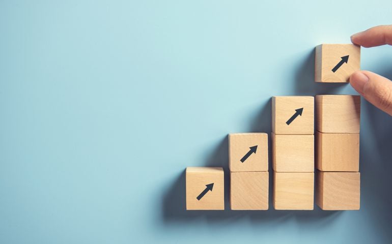 Hand arranging wood block stacking as step stair on paper pink background. Business concept growth success process, copy space.