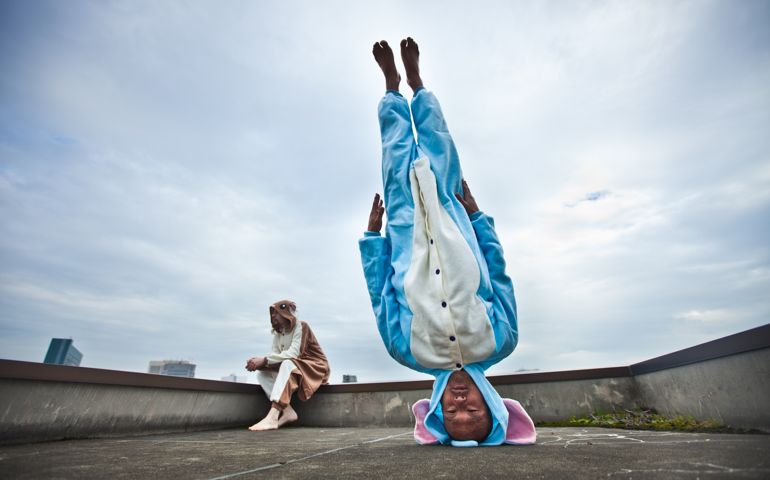 Japanese man standing on his head in elephant costume
