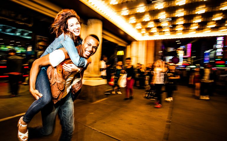 Couple having fun at night on Broadway, New York City.